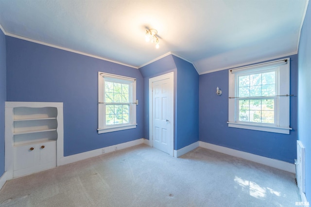 unfurnished bedroom featuring lofted ceiling, light colored carpet, and multiple windows