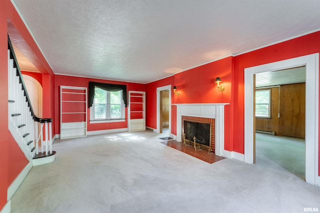 unfurnished living room with carpet floors, baseboard heating, a fireplace, and a textured ceiling