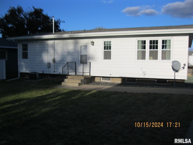 rear view of property with a yard