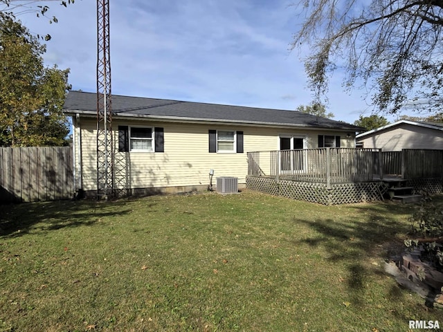 rear view of property featuring cooling unit, a wooden deck, and a yard