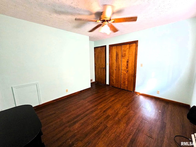 unfurnished bedroom featuring dark hardwood / wood-style flooring, a textured ceiling, and ceiling fan