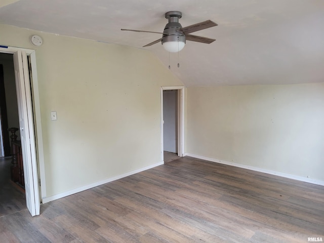 spare room with dark hardwood / wood-style flooring, vaulted ceiling, and ceiling fan