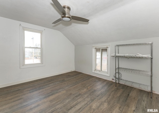 additional living space featuring a ceiling fan, dark wood-style flooring, vaulted ceiling, and baseboards