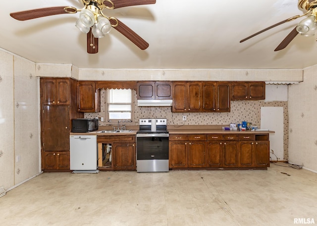 kitchen featuring stainless steel electric range oven, a sink, black microwave, dishwasher, and under cabinet range hood