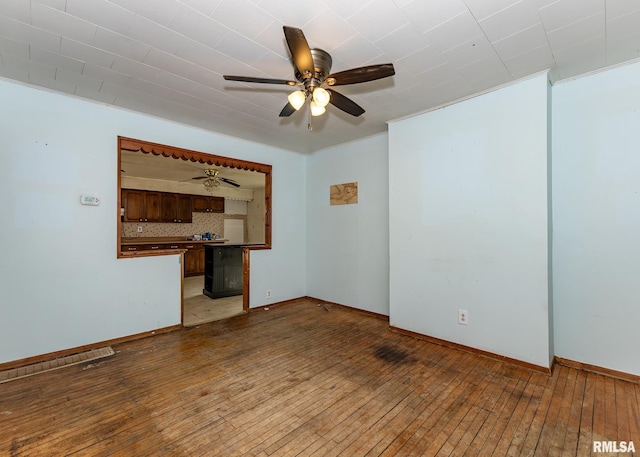 unfurnished room with light wood-style floors, ceiling fan, and baseboards