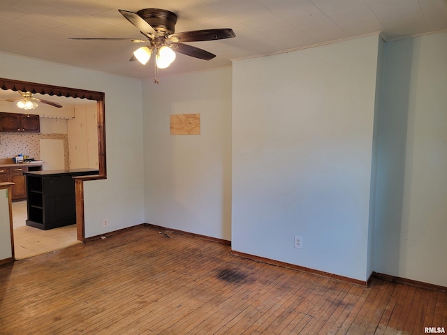 unfurnished room with ceiling fan, light wood-type flooring, and ornamental molding