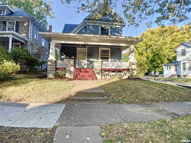 view of front of home featuring covered porch and a front yard