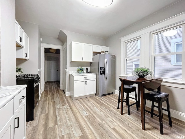 kitchen featuring white cabinets, light wood-type flooring, and appliances with stainless steel finishes