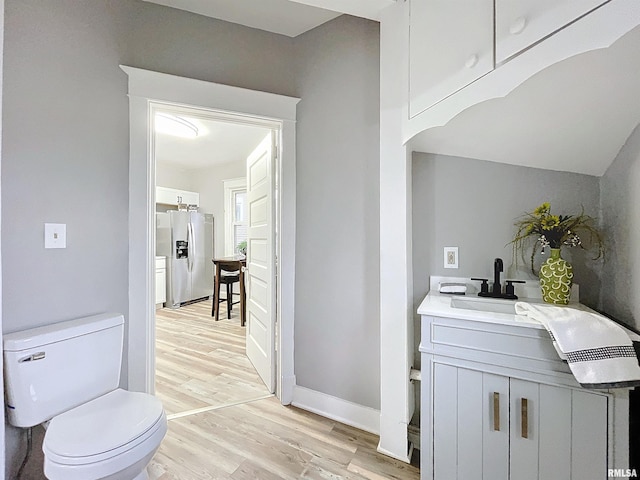 bathroom featuring hardwood / wood-style flooring, vanity, and toilet