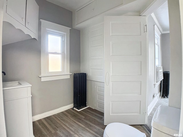 bathroom featuring hardwood / wood-style floors, vanity, toilet, and radiator