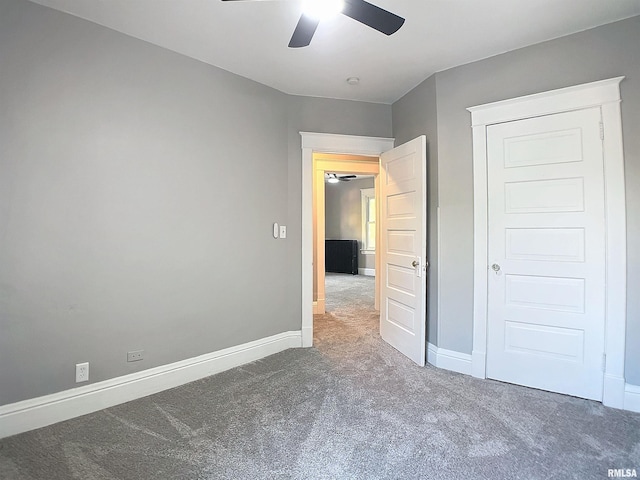 unfurnished bedroom with ceiling fan and dark carpet