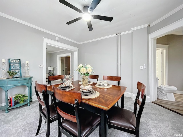 carpeted dining area featuring ceiling fan and crown molding