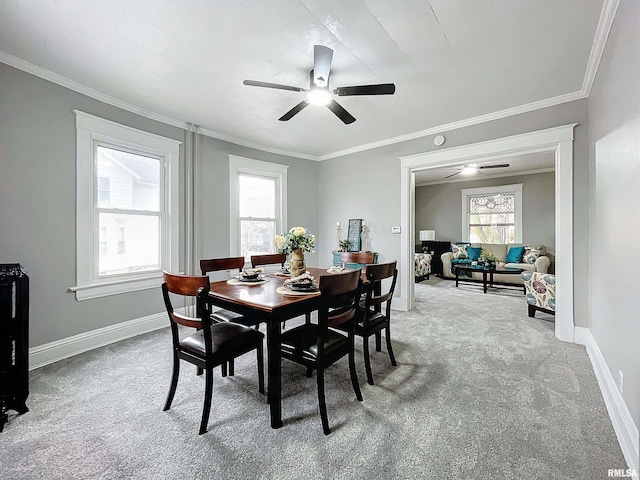 carpeted dining room featuring a wealth of natural light, crown molding, and ceiling fan