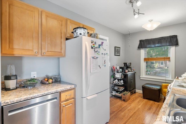 kitchen with light brown cabinets, white refrigerator, sink, dishwasher, and light wood-type flooring