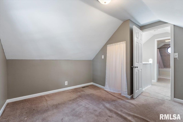 bonus room with lofted ceiling and carpet