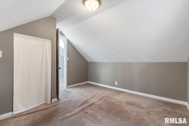 additional living space featuring lofted ceiling and light colored carpet