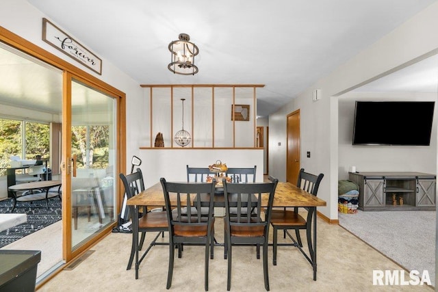 dining area with a chandelier and light carpet