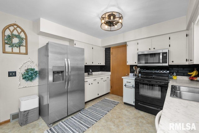 kitchen featuring sink, decorative backsplash, appliances with stainless steel finishes, and white cabinetry