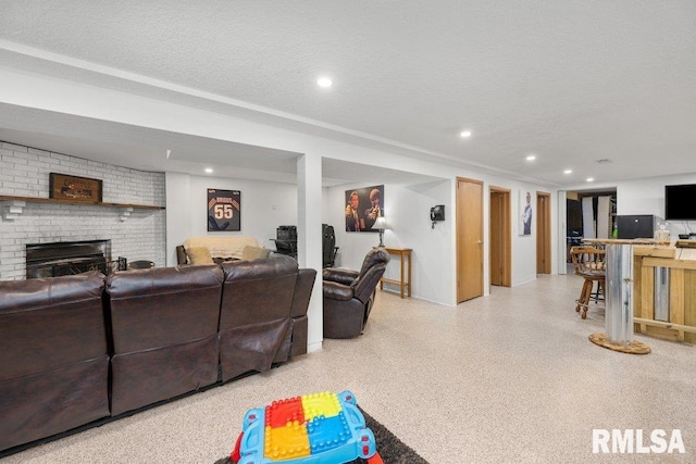 living room with a textured ceiling and a fireplace