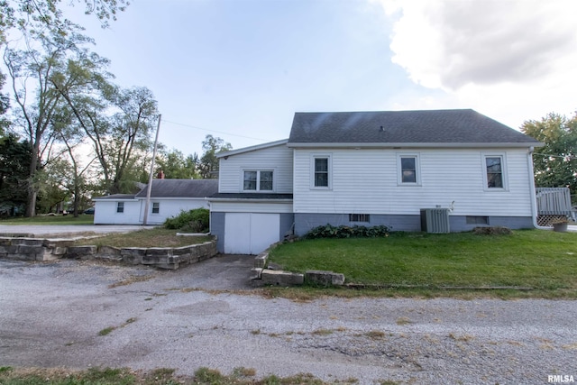 rear view of property with central AC and a lawn