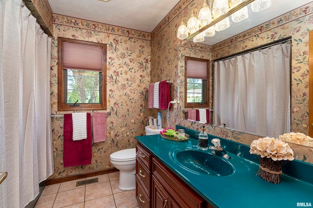 bathroom with vanity, toilet, tile patterned floors, and a textured ceiling