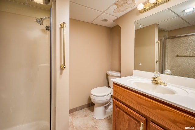 bathroom with toilet, a drop ceiling, vanity, and walk in shower