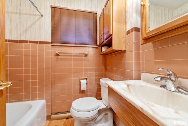 full bathroom with vanity, toilet, and tile walls