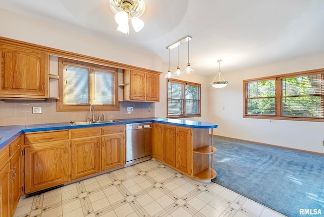 kitchen with dishwasher, kitchen peninsula, hanging light fixtures, sink, and tasteful backsplash