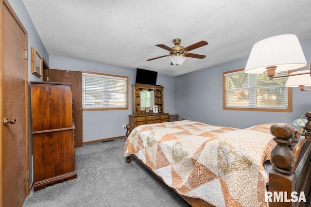 carpeted bedroom featuring a textured ceiling and ceiling fan