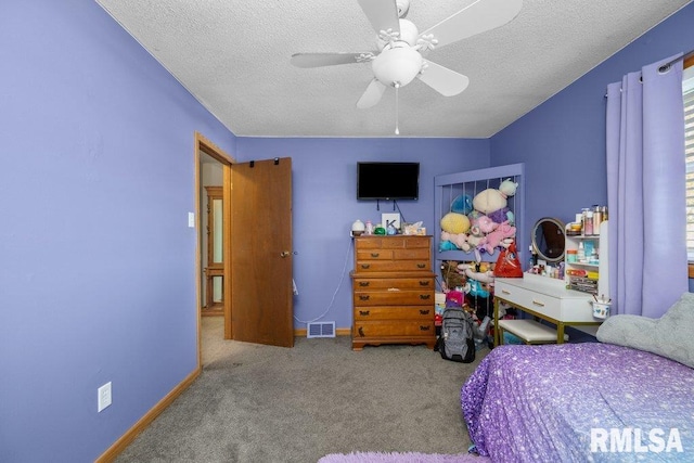 bedroom with a textured ceiling, carpet floors, and ceiling fan