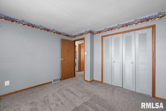 unfurnished bedroom featuring carpet, a textured ceiling, and a closet