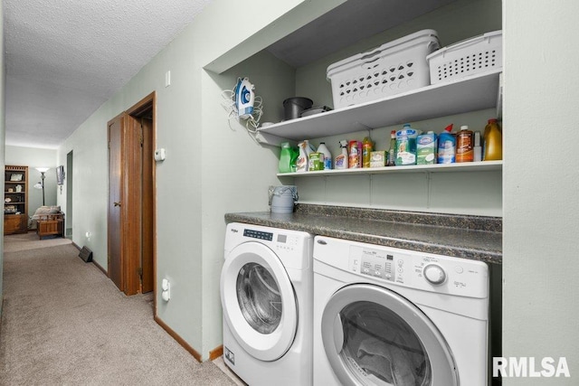 clothes washing area with a textured ceiling, separate washer and dryer, and light colored carpet