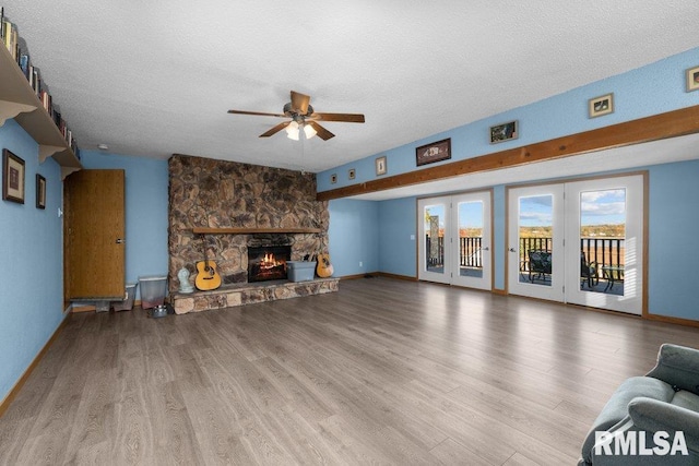 living room with a fireplace, a textured ceiling, and light wood-type flooring