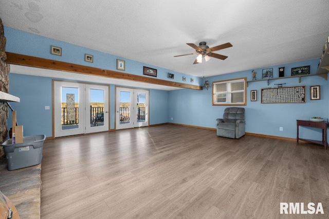 unfurnished living room with french doors, ceiling fan, a textured ceiling, and light wood-type flooring