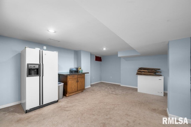 interior space with white fridge with ice dispenser and light colored carpet