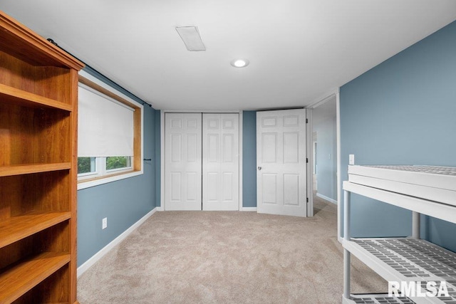 unfurnished bedroom with light carpet and a closet