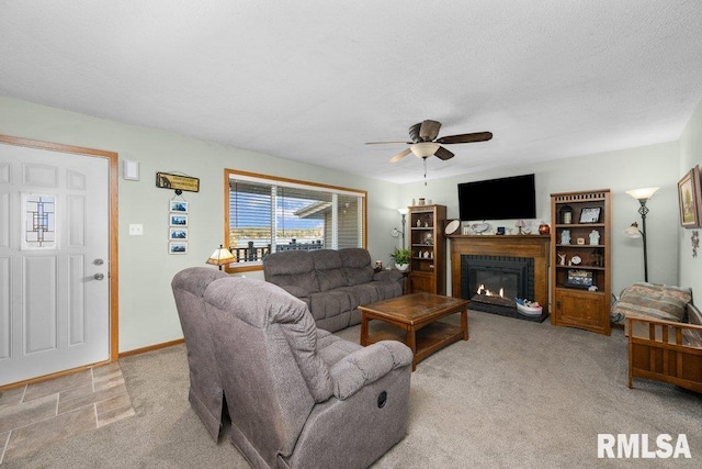 carpeted living room featuring a textured ceiling and ceiling fan