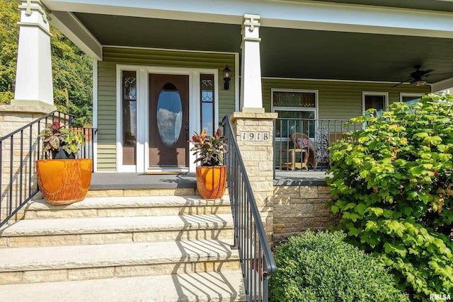 view of exterior entry with ceiling fan and a porch