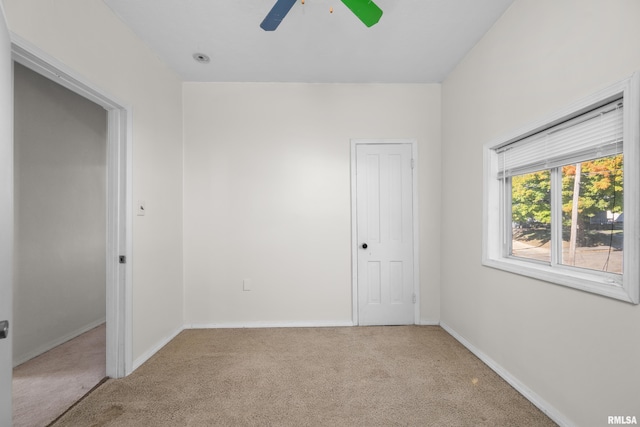 carpeted spare room featuring ceiling fan