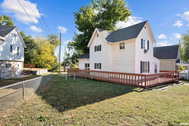 rear view of property with a deck and a lawn