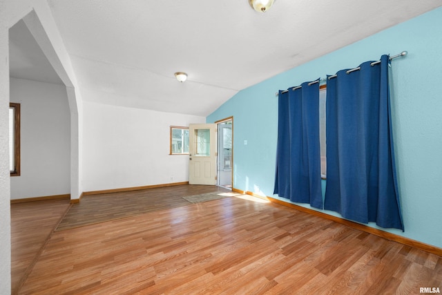 empty room with lofted ceiling and wood-type flooring