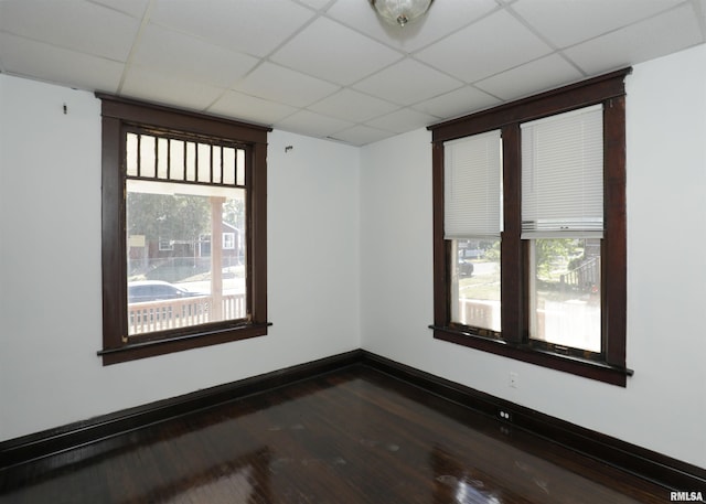 spare room featuring a wealth of natural light, dark hardwood / wood-style floors, and a paneled ceiling