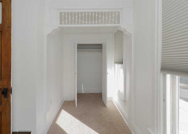 unfurnished bedroom featuring light carpet, multiple windows, and a closet