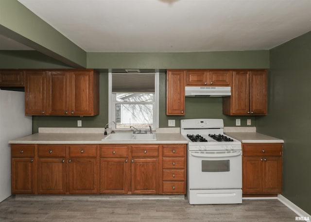 kitchen featuring white appliances, sink, and light wood-type flooring