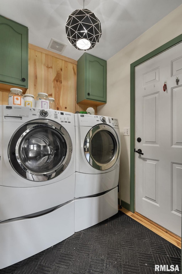 washroom with cabinets and washing machine and clothes dryer