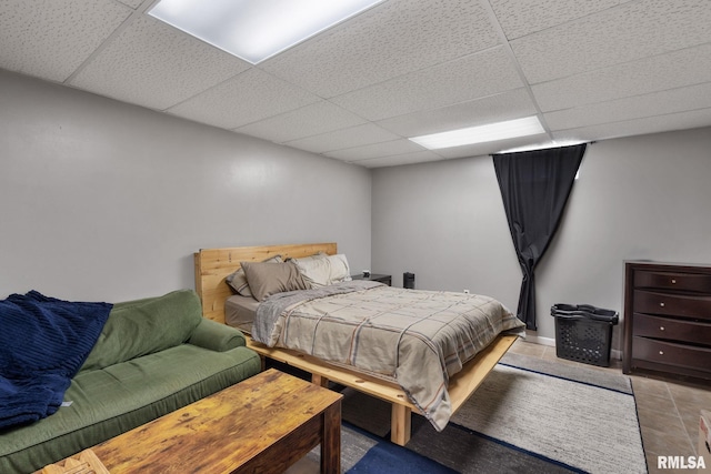 bedroom featuring a paneled ceiling and light tile patterned floors