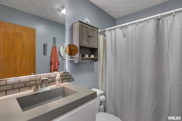 bathroom with curtained shower, vanity, toilet, and backsplash