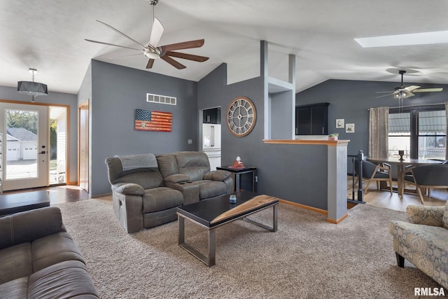 living room featuring lofted ceiling with skylight, hardwood / wood-style flooring, and ceiling fan