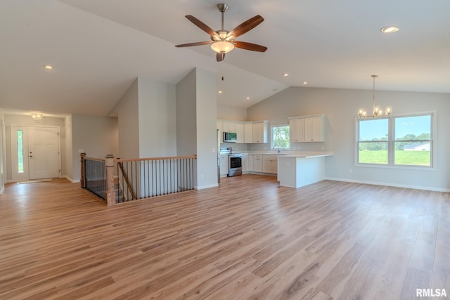 941 9th Ave N, Clinton, IA 52732 - unfurnished living room featuring light wood-style floors, a chandelier, a ceiling fan, recessed lighting, and high vaulted ceiling