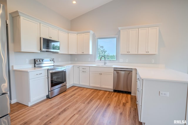 941 9th Ave N, Clinton, IA 52732 - kitchen with appliances with stainless steel finishes, light wood-style floors, white cabinets, vaulted ceiling, and recessed lighting